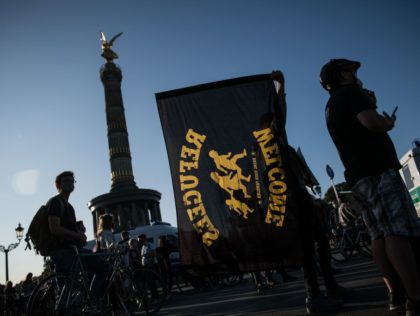 A protester holds a flag reading "Refugees welcome" during a demonstration for t