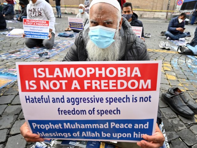 Muslim faithfuls hold placards as they pray during a gathering on October 30, 2020 in central Rome called against islamophobia and for boycotting France amid anger in the Islamic world over French President's defence of the right to publish cartoons seen as offencive to Islam. - French President made the …
