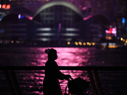 A woman pushes a baby stroller as she walks on a promenade that runs along Victoria Harbour in Hong Kong on December 14, 2020. (Photo by ANTHONY WALLACE / AFP) (Photo by ANTHONY WALLACE/AFP via Getty Images)