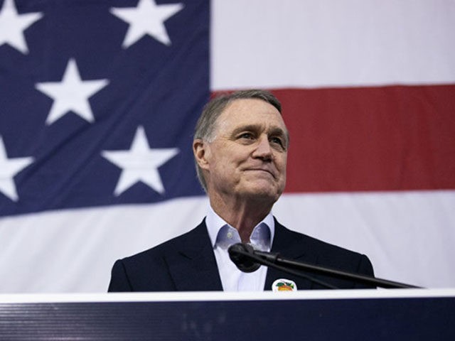 ATLANTA, GA - DECEMBER 14: Sen. David Perdue (R-GA) addresses the crowd during a campaign rally at Peachtree Dekalb Airport on December 14, 2020 in Atlanta, Georgia. As early voting begins, Perdue is facing Democratic candidate Jon Ossoff in a runoff election. The results of two Georgia Senate races will …