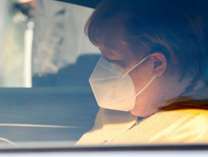 German Chancellor Angela Merkel wears a face mask as she sits in her car after holding a p