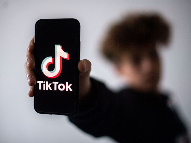 A teenager presents a smartphone with the logo of Chinese social network Tik Tok, on Janua
