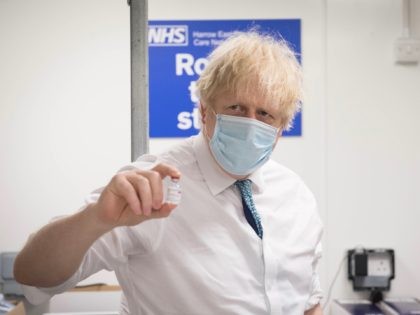 Prime Minister Boris Johnson sees how a dose of the Oxford/AstraZeneca Covid 19 vaccine is prepared for a mobile vaccination centre during a visit to Barnet FC's ground at The Hive, north London, which is being used as a coronavirus vaccination centre on January 25, 2021. (Photo by Stefan Rousseau …