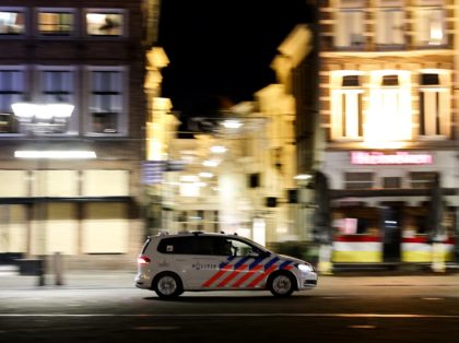 A Dutch police car patrols in the deserted streets of Den Bosch during the curfew time, on