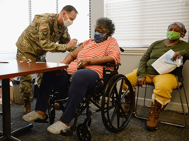 Staff Sergeant Herbert Lins of the Missouri Army National Guard administers the Covid-19 vaccine to a resident during a vaccination event on February 11, 2021 at the Jeff Vander Lou Senior living facility in St Louis, Missouri. The Urban League of Metropolitan St. Louis is hosting vaccination events in and …