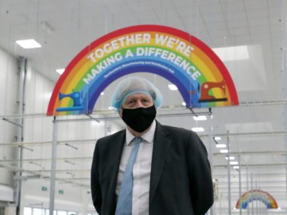 Britain's Prime Minister Boris Johnson , wearing a face mask and a hair net visits the Northumbria Healthcare NHS Trust personal protective equipment (PPE) manufacturing hub in Seaton Delaval, northeast England, on February 13, 2021 during a one-day visit to the region to visit manufacturing facilities and see the ongoing …