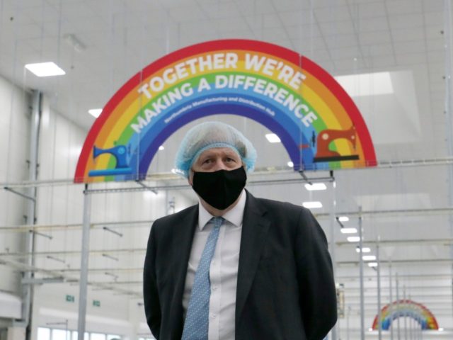 Britain's Prime Minister Boris Johnson , wearing a face mask and a hair net visits th