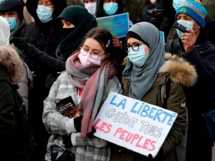A woman holds a placard reading "Freedom leads all the people" as protesters demonstrate against a bill dubbed as "anti-separatism", in Paris on February 14, 2021. - French lawmakers a few weeks ago began debating a controversial bill against what the interior minister described as the "disease" of Islamist extremism …