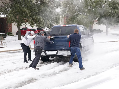 Residents help a pickup driver get out of ice on the road in Round Rock, Texas, on February 17, 2021, after a winter storm. - Millions of people were still without power on Wednesday in Texas, the oil and gas capital of the United States, and facing water shortages as …