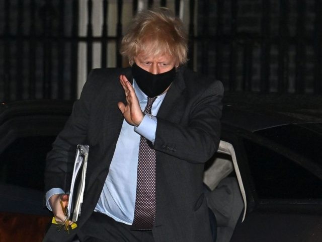 Britain's Prime Minister Boris Johnson, waring a face covering, returns to 10 Downing Street in central London after making a statement to Parliament on the government's roadmap out of lockdown on February 22, 2021. - The UK government on Monday set out a four-step plan to ease coronavirus restrictions, expressing …