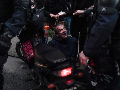 Motorised police officers detain a protester during a demonstration in Athens on February