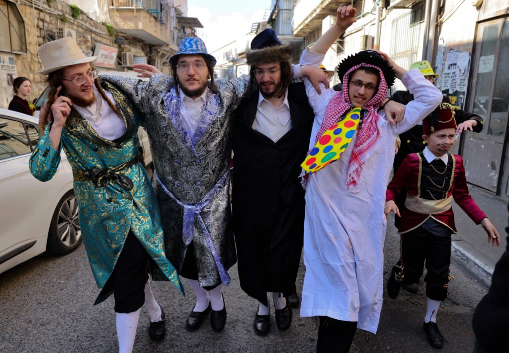 Orthodox Jewish men, dressed in costumes to celebrate Purim, are pictured in the neighbourhood of Mea Shearim in Jerusalem, on February 28, 2021. (MENAHEM KAHANA/AFP via Getty Images)