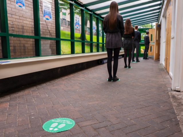 HYDE, ENGLAND - JULY 16: Pupils queue to enter the canteen at Longdendale High School on J