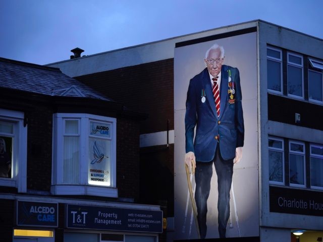 SOUTHPORT, ENGLAND - FEBRUARY 03: A mural of Captain Sir Tom Moore, by artist Robert Newbiggin, adorns a wall on February 03, 2021 in Southport, England. WWII veteran, Sir Tom had raised nearly £33 million for NHS charities ahead of his 100th birthday last year by walking laps of his …