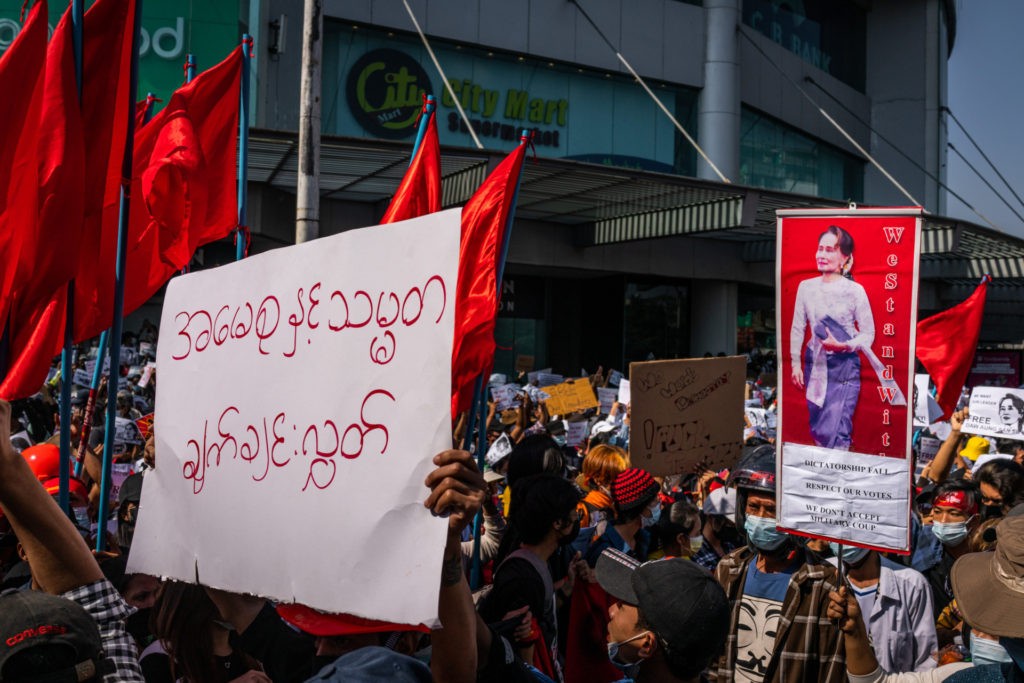 YANGON, MYANMAR - FEBRUARY 09: Protesters hold images of de-facto leader Aung San Suu Kyi on February 09, 2021 in Yangon, Myanmar. Myanmar declared martial law in parts of the country, including its two largest cities, as massive protests continued to draw people to the streets a week after the country's military junta staged a coup against the elected National League For Democracy (NLD) government and detained de-facto leader Aung San Suu Kyi. Police fired rubber bullets, tear gas, and water cannon to disperse protesters at demonstrations across the country, and at least two people were in critical condition from the injuries sustained. (Photo by Hkun Lat/Getty Images)