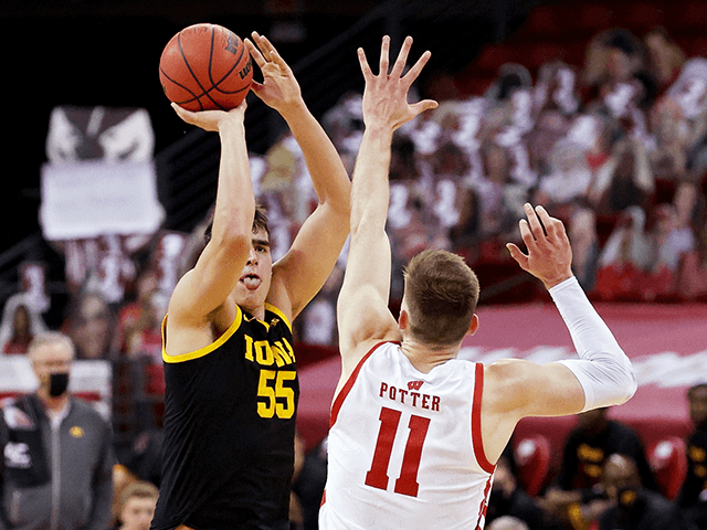 Luka Garza #55 of the Iowa Hawkeyes attempts a shot while being guarded by Micah Potter #1