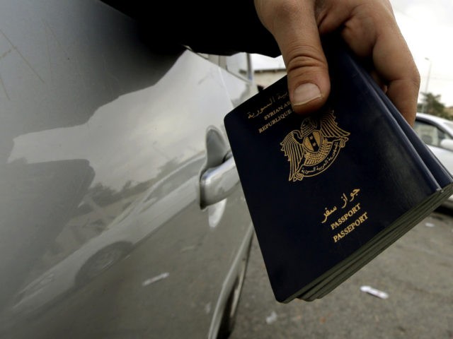A man holds Syrian passports as he waits at the Masnaa Lebanese border crossing with Syria