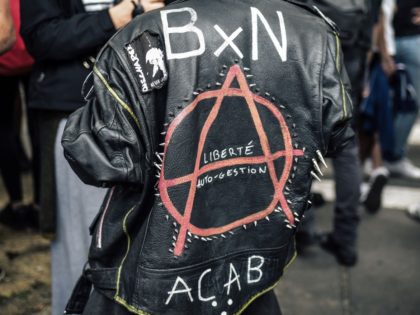 A protester wears a leather jacket bearing the circle-A, an anarchist symbol, and the acronym ACAB which means "All Cops Are Bastards" (or sometimes "All Capitalists Are Bastards") during a demonstration against France's immigration and asylum law and facism in Paris on June 2, 2018. (Photo by LUCAS BARIOULET / …