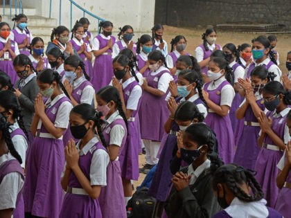 Students wearing facemasks attend their assembly prayer after the schools for classes 9th