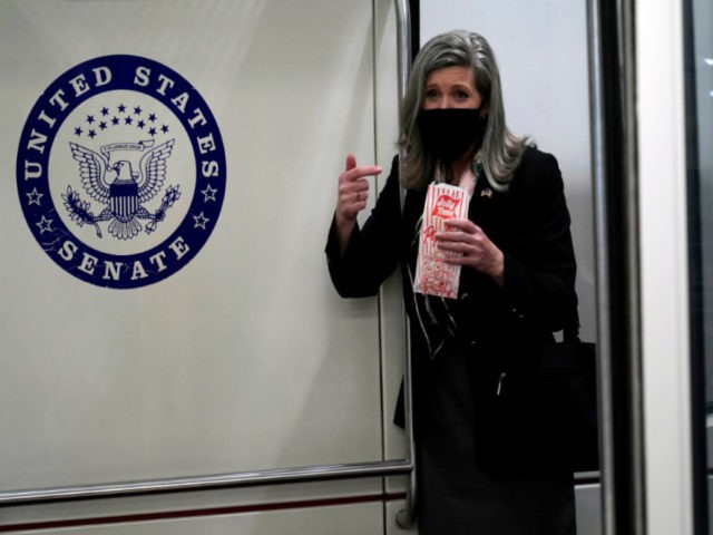 Sen. Joni Ernst, R-Iowa, holds popcorn as she rides the Senate subway on Capitol Hill in W