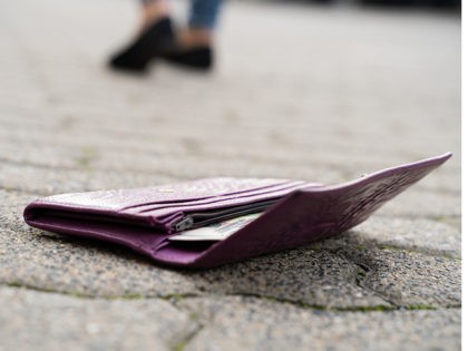 Woman Walking Against Fallen Wallet On Street