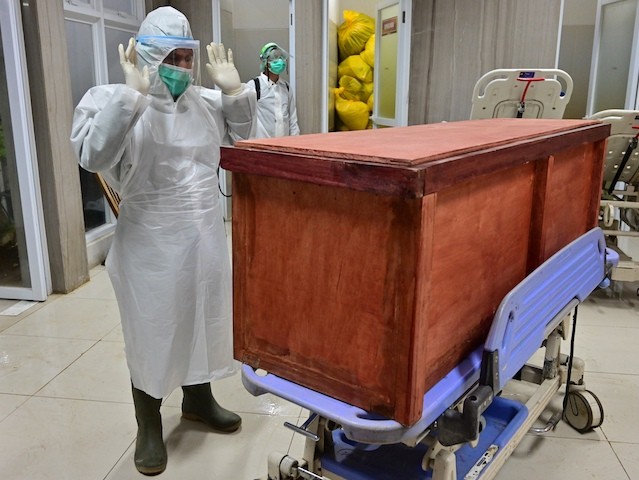 This September 2020 picture shows a hospital worker performing a Muslim funeral prayer over the coffin bearing the body of a patient who succumbed to the Chinese coronavirus. (Adek Berry/AFP via Getty Images)