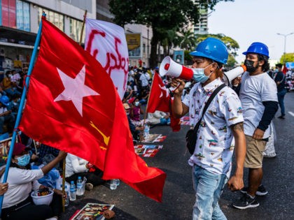 YANGON, MYANMAR - FEBRUARY 17: Protesters wave flags and shout anti-coup slogans on February 17, 2021 in Yangon, Myanmar. Armored vehicles continued to be seen on the streets of Myanmar's capital, but protesters turned out despite the military presence. The military junta that staged a coup against the elected National …