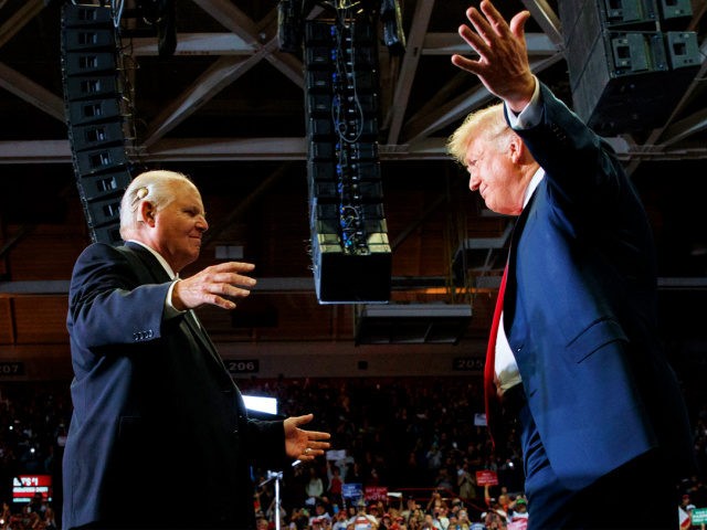 President Donald Trump opens his arms to Rush Limbaugh as he arrives to speaks during a ra