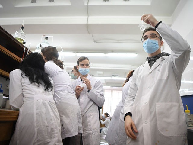 Students wearing face masks conduct experiments during a chemistry practical class at the