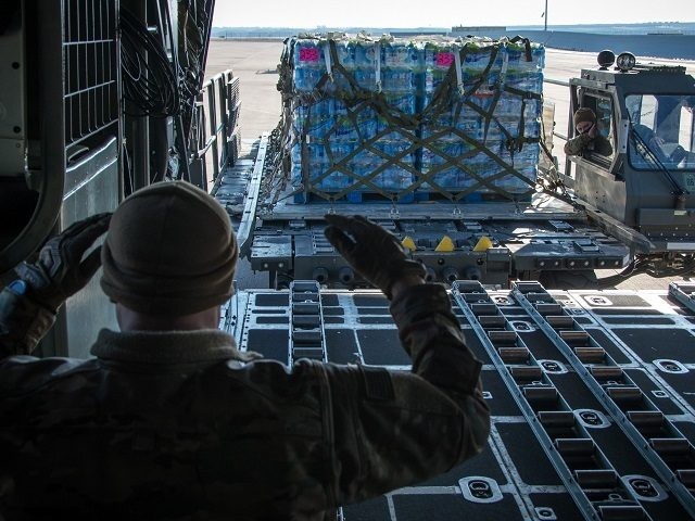 Texas Air National Guardsmen from the 181st Airlift Squadron load pallets of water on a C-