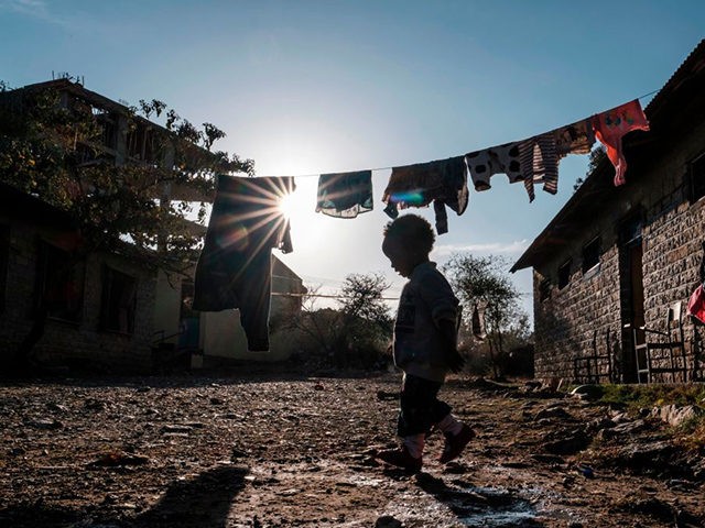 A displaced child from Western Tigray walks outside of a classroom in the school where the family is sheltering in Tigray's capital Mekele on February 24, 2021. - Many of the city's schools are now camps for the displaced. Its pediatric wards teem with children nursing bullet and shrapnel wounds, …