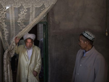 In this September 2016 file photo, Uyghur men leave after eating a holiday meal during the