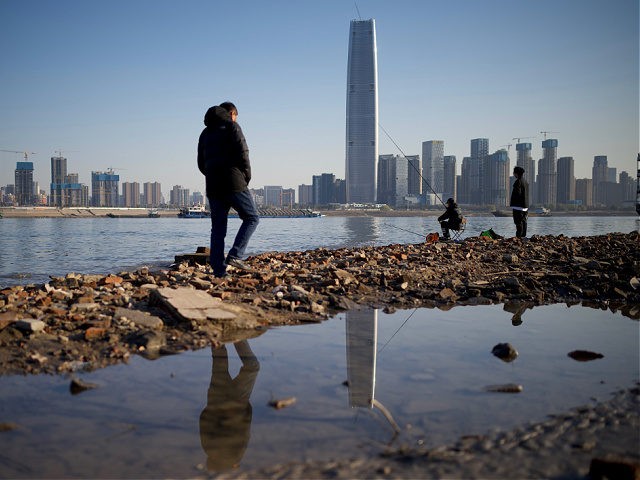 People walk along the banks of the Yangtze River on New Year's Eve day in Wuhan in Chinas central Hubei province on December 31, 2020. (Photo by Noel Celis / AFP) (Photo by NOEL CELIS/AFP via Getty Images)
