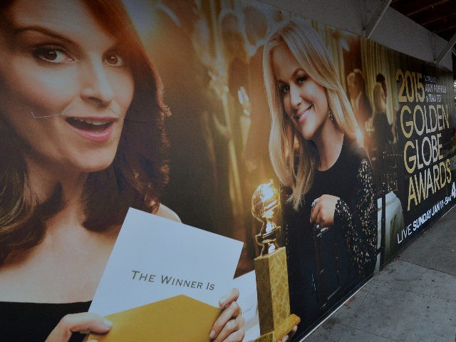 Commuters walk past a poster showing the Golden Globe Award hosts Tina Fey (L) and Amy Poehler (R) in Beverly Hills on January 9, 2015. The comic duo will present the Globes for a third and final year, in what organizers hope will continue its ratings winning streak. Last year …