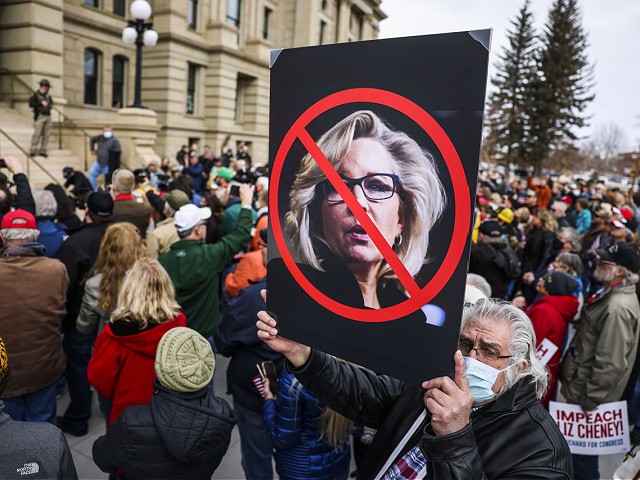 CHEYENNE, WY - JANUARY 28: A man holds up a sign against Rep. Liz Cheney (R-WY) as Rep. Matt Gaetz (R-FL) speaks to a crowd during a rally against her on January 28, 2021 in Cheyenne, Wyoming. Gaetz added his voice to a growing effort to vote Cheney out of office after she voted in favor of impeaching Donald Trump. (Photo by Michael Ciaglo/Getty Images)