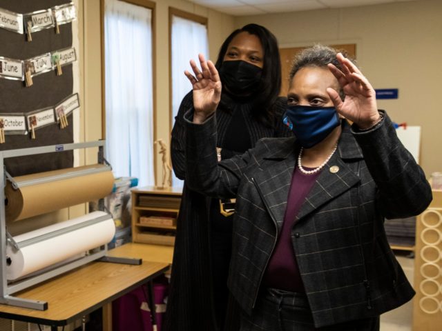 Mayor Lori Lightfoot, right, and Chicago Public Schools CEO Janice Jackson wave to preschool students who did not come to class in person but are learning virtually at at Dawes Elementary School in Chicago, Monday, Jan. 11, 2021. Monday was the first day of optional in-person learning for preschoolers and …