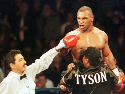 Boxer Mike Tyson of the United States (top R) exhorts Andrew Golota of Poland (not pictured) to continue fighting as referee Frank Garza Jr. raises his hand awarding him a TKO after Golota refused to answer the bell for the third round of their fight at the Palace of Auburn …