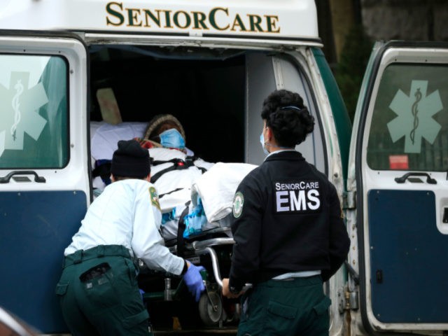 Emergency Medical Service workers unload a patient out of their ambulance at the Cobble Hill Health Center on April 18, 2020 in the Cobble Hill neighborhood of the Brooklyn borough of New York City. The nursing home has had at least 55 COVID-19 reported deaths. (Photo by Justin Heiman/Getty Images)