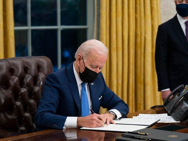 FILE - In this Tuesday, Feb. 2, 2021, file photo, Secretary of Homeland Security Alejandro Mayorkas looks on as President Joe Biden signs an executive order on immigration, in the Oval Office of the White House in Washington. Faith-based organizations involved in refugee resettlement are celebrating President Joe Biden’s new executive order that intends to lift the number of refugees admitted to the U.S. to 125,000 — a massive increase compared to reduced numbers under former President Trump. (AP Photo/Evan Vucci, File)