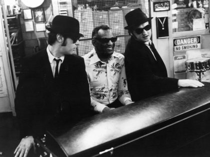Dan Aykroyd listens as Ray Charles plays piano next to John Belushi in a scene from the fi