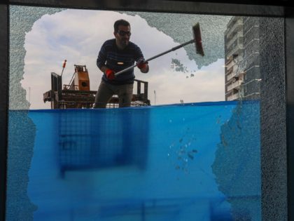A worker cleans shattered glass on February 16, 2021 outside a damaged shop following a rocket attack the previous night in Arbil, the capital of the northern Iraqi Kurdish autonomous region. - The United Nations warned Iraq could spin out of control after a rocket attack on the Kurdish regional …