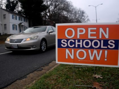 A sign in support of opening schools amid the Covid -19 pandemic sits on a street in Arlington, Virginia on December 1, 2020. - In the ensuing months as coronavirus restrictions for the state of Virginia were redefined, schools closed for the remainder of the year, then summer activities were …