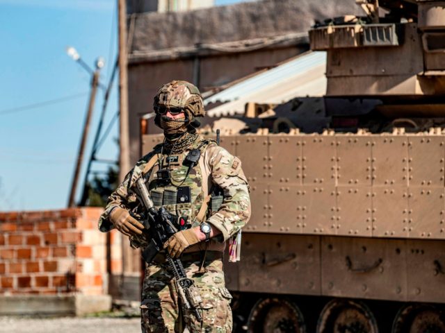 A US soldier stands by a Bradley Fighting Vehicle (BFV) during a patrol in the countryside near al-Malikiyah (Derik) in Syria's northeastern Hasakah province on February 2, 2021. (Photo by Delil SOULEIMAN / AFP) (Photo by DELIL SOULEIMAN/AFP via Getty Images)