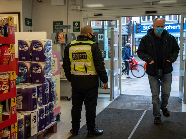 LONDON, ENGLAND - JANUARY 12: A security guard stands by the entrance to a Morrisons supermarket as a customer wearing a face mask enters the store on January 12, 2021 in London, United Kingdom. In response to government ministers voicing concerns about the public's behaviour in supermarkets, Sainsbury's and Morrisons …