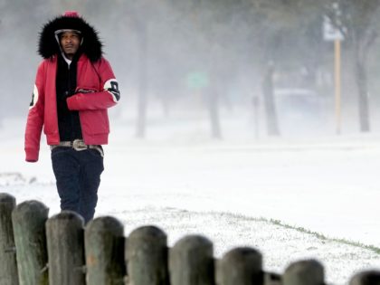 Igee Cummings walks through the snow Monday, Feb. 15, 2021, in Houston. A winter storm dropping snow and ice sent temperatures plunging across the southern Plains, prompting a power emergency in Texas a day after conditions canceled flights and impacted traffic across large swaths of the U.S. (AP Photo/David J. …