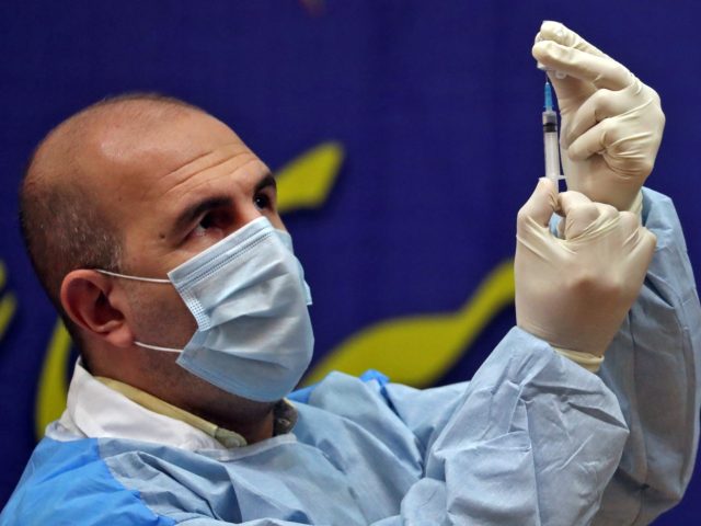 An Iranian health worker prepares a dose of the COVID-19 vaccine as the country launches i