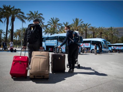 Tourists prepare to board buses upon arrival at the Son Sant Joan airport in Palma de Mallorca on June 22, 2020 as EU member state citizens and those from the passport-free Schengen zone were allowed freely into Spain, with no 14-day quarantines required following a national lockdown to stop the …