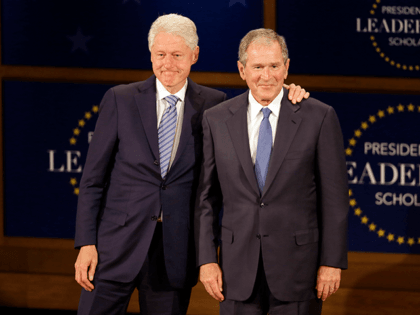Former presidents Bill Clinton, left, and George W. Bush, right, stand on stage acknowledg