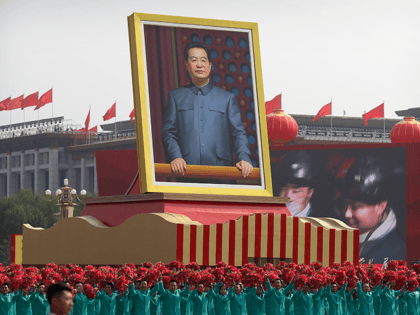 Participants wave floral bouquets as they march next to a large portrait of Chinese leader