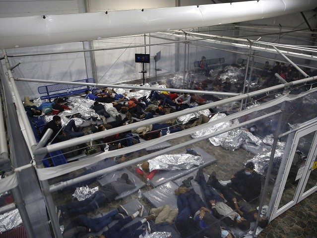 Minor children are housed inside a pod at the Donna Department of Homeland Security holding facility, the main detention center for unaccompanied children in the Rio Grande Valley run by U.S. Customs and Border Protection (CBP), in Donna, Texas, Tuesday, March 30, 2021. The minors are housed by the hundreds in eight pods that are about 3,200 square feet in size. Many of the pods had more than 500 children in them. The Biden administration on Tuesday for the first time allowed journalists inside its main detention facility at the border for migrant children, revealing a severely overcrowded tent structure where more than 4,000 kids and families were crammed into pods and the youngest kept in a large play pen with mats on the floor for sleeping.(AP Photo/Dario Lopez-Mills, Pool)